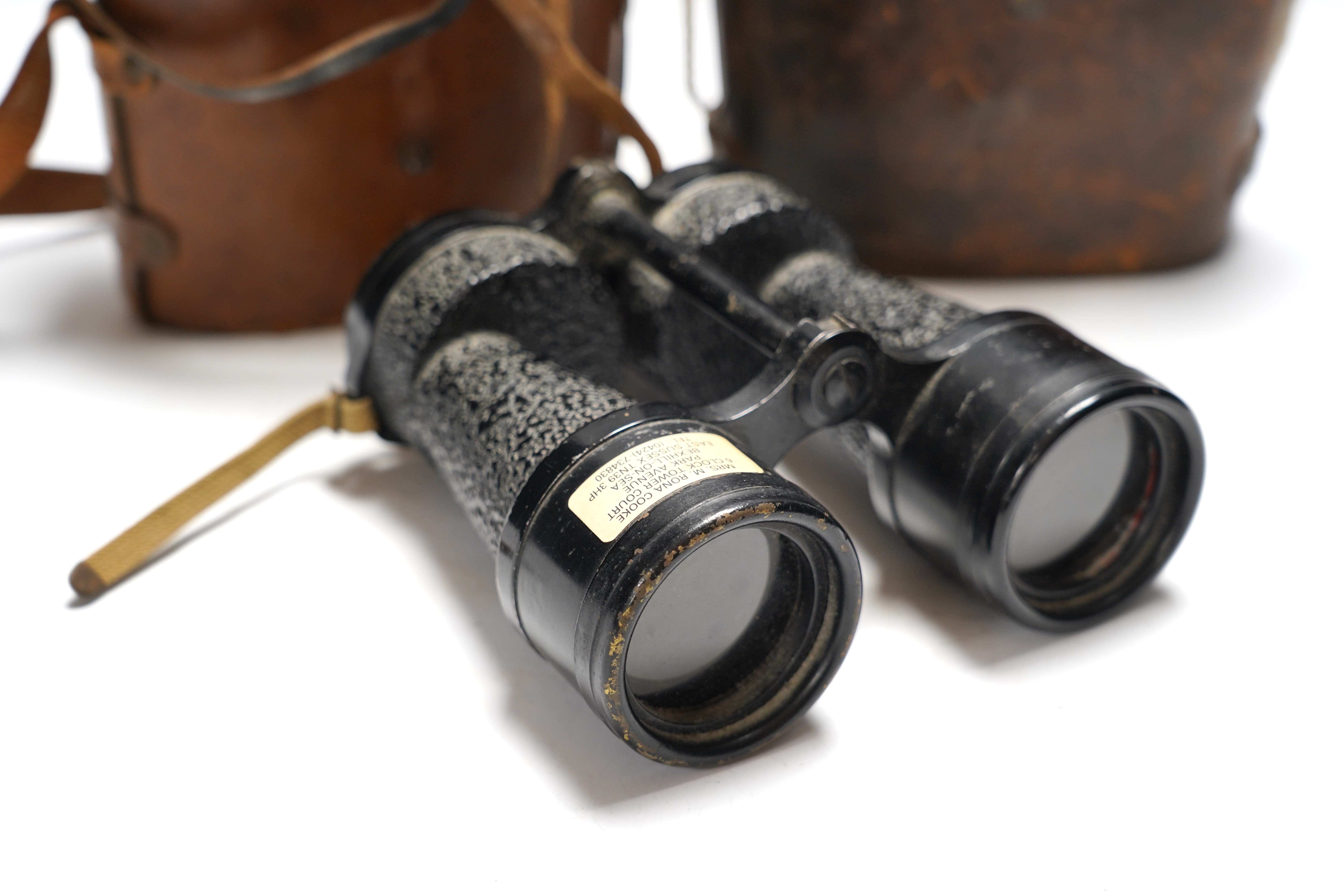 Two cased pairs of binoculars and a brass bugle.